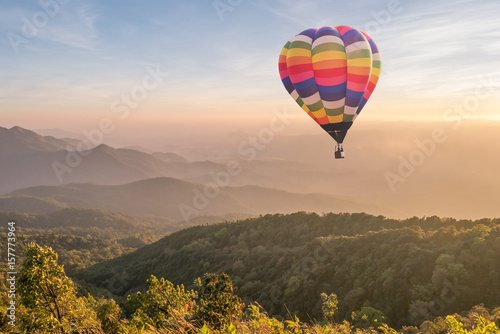 Plakat Kolorowy gorące powietrze balon nad górą przy zmierzchem