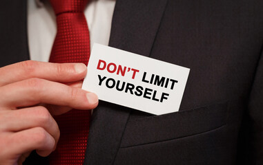 Poster - businessman putting a card with text don't limit yourself in the pocket