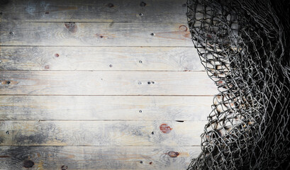 Fishing nets over wooden background with copy space.