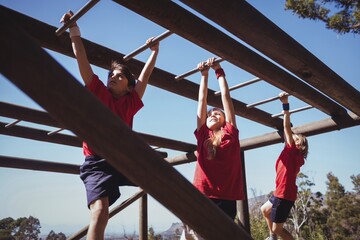 Wall Mural - kids climbing horizontal bars during obstacle course training
