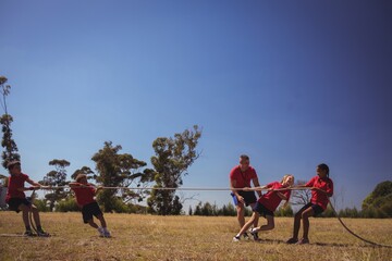 Wall Mural - kids playing tug of war during obstacle course training