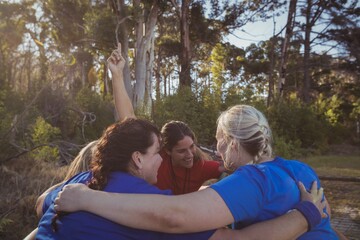 Wall Mural - Group of fit women forming huddles in the boot camp