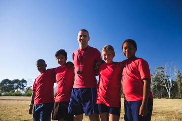 Wall Mural - trainer and kids standing together in the boot camp