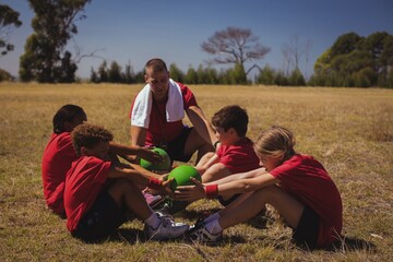 Wall Mural - trainer instructing kids while exercising in the boot camp