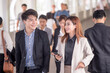 © Jestercine - Quick briefing before meeting. young asian business people talking to each other while walking outdoors, 20-30 year old.
