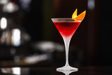 Fototapeta  - Closeup glass of cosmopolitan cocktail decorated with orange at bar background.