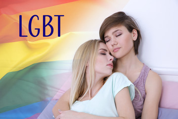 Wall Mural - Young lesbian couple sitting on bed at home