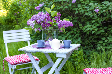 Wall Mural - Lilac flowers on table in beautiful garden