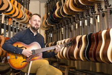 Smiling Man Playing Guitar In Shop