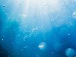 Bubbles underwater in sea and sun rays. Water texture in ocean