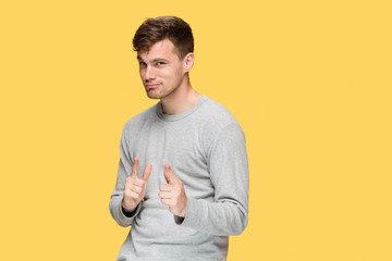 Wall Mural - The young man smiling and looking and pointing at cameraaway