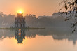 Sun rising behind the Turtle Tower in the center of Hoan Kiem Lake (Lake of the Returned Sword). The lake is one of the major scenic spots in the city and serves as a focal point for its public life.