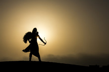 Young Woman With A Bow And An Arrow In A Desert
