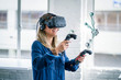 A female student wearing a virtual reality headset interacts with a 3D scientific model.