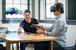 © db - Business colleagues review automotive design concepts wearing a virtual reality headset.