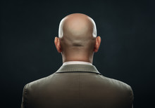 The Back Of A Bald Man In Suit