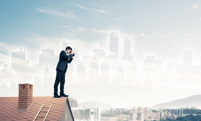 Businessman standing on roof and looking in binoculars. Mixed me