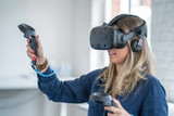 Fototapeta Sypialnia - Young woman wearing a virtual reality headset.
