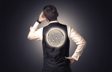 Businessman standing with maze on his back