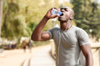 © javiindy - Young black man drinking water before running in urban background