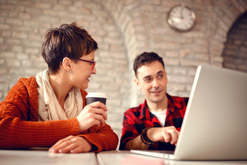 Poster - young designer couple working late at computer .