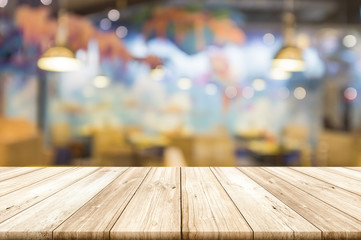 Wall Mural - Empty wooden table top with blurred restaurant interior background.