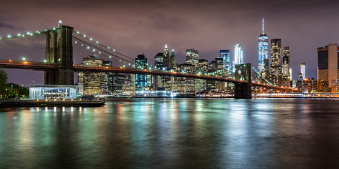 Fototapete - Panoramic view of the Brooklyn Bridge with Financial District skyscrapers at twilight and light clouds. Lower Manhattan, New York City