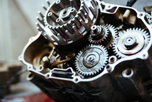 Closeup Image Of Metal Car Part With Gears Smudged With Machine Oil On Table In Mechanics Workshop