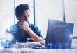 © SFIO CRACHO - Concept of digital screen,virtual connection icon,diagram,graph interfaces.Young banking finance analyst working at office on laptop.Businessman analyze stock reports.Blurred background,horizontal.