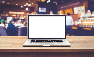 Wall Mural - Modern computer,laptop with blank screen on table with blur cafe,restaurant backgrounds.