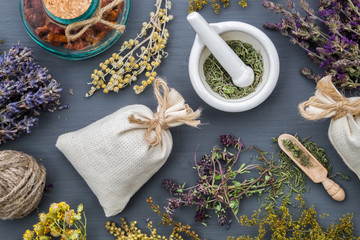 Wall Mural - Medicinal herbs, mortar of healing herbs, sachet and bottle of healthy drugs on wooden table. Herbal medicine. Top view, flat lay.