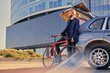 © Fxquadro - A man holds fixed bicycle near the car with open trunk.