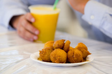 Homemade Fritters With Sugar And Its Ingredients With A Blurred Orange Glass Of Juice Behind