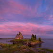 White Night On The White Sea Coast.Village Rabocheostrovsk,Karelia.Old Russian Orthodox Wooden Church On Island With Pink Sky After Severe Storm.Place Where  Filmed Movie 