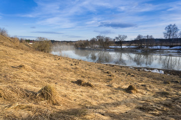 Spring landscape with the river fog and the sun