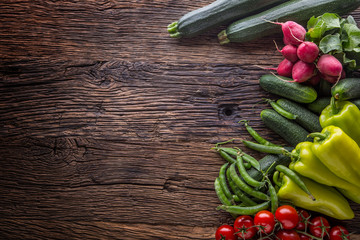 Wall Mural - Vegetable.Fresh vegetable tomato radish green pepper peas zucchini and cucumber on rustic oak table.