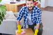 © ArtFamily - Handsome sir in gloves mopping coffee table