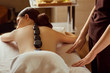 © Studio Romantic - Massage stones on  back of a woman at the spa salon.