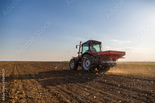 Zdjęcie XXL Rolnik nawożący ziemię uprawną za pomocą azotu, fosforu, nawozu potasowego