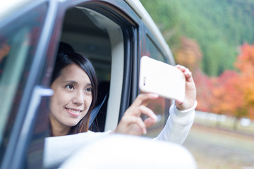 Poster - Woman taking photo inside a car