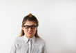 © shurkin_son - Comic portrait of young offended female in striped shirt and glasses with a raised eyebrow and looking away with angry or irritated expression on her face. Negative womans emotions on her period
