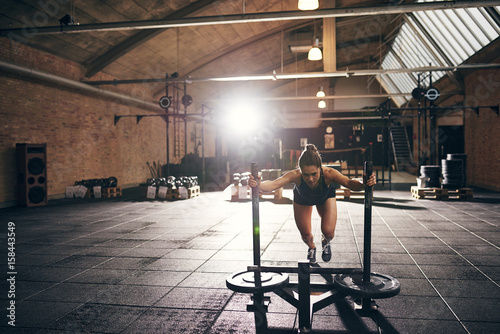 Fotografía Woman doing hard push-up exercise in gym
