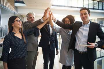 Wall Mural - Business team giving high five in office