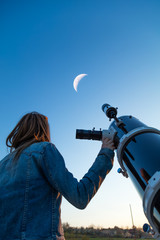 Wall Mural - girl looking at the moon through a telescope. my astronomy work.