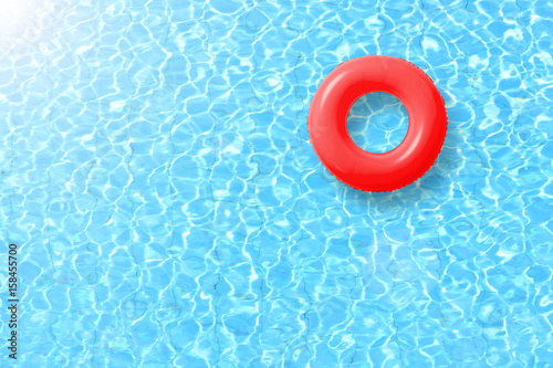 Fotografía red swimming pool ring float in blue water and sun bright