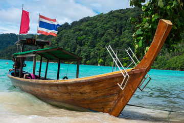 longtail boat of fisherman parking on sand beach have sea and mountain are background. this image for nature,seascape,travel and transport concept