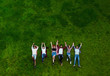 © Tijana - Group of young people laying on the grass in circle, happy, smiling