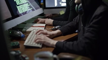 Wall Mural - tilt up of young male and female hackers fishing websites at night