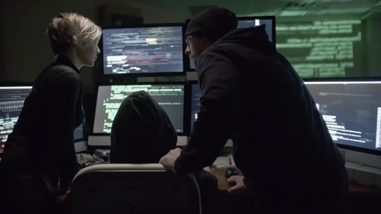 Wall Mural - rear view of three hackers trying to gain access to web server. man typing commands on six computer 