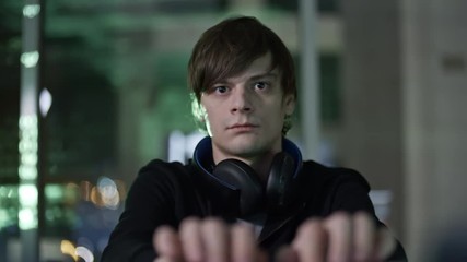 Wall Mural - concentrated young man with headphones around his neck typing on computer keyboard at desk in the da